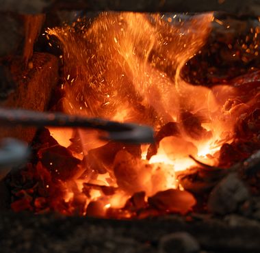 Segrevanje kovine v žerjavici tradicionalne kovaške peči na Zelenem krasu.