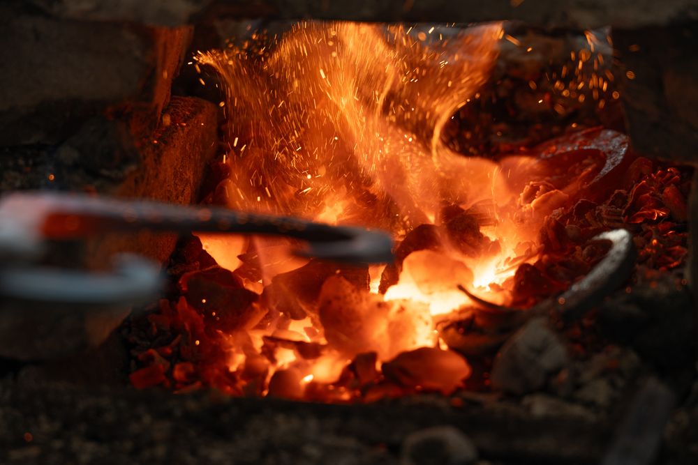 Segrevanje kovine v žerjavici tradicionalne kovaške peči na Zelenem krasu.